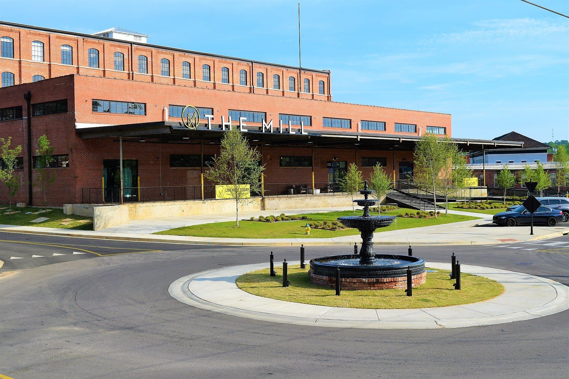 The restored Pratt cotton gin factory beside a fountain roundabout